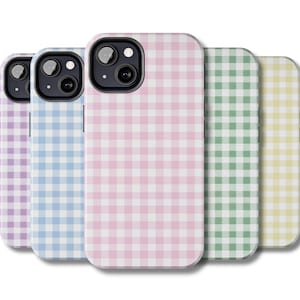 May include: A collection of five phone cases in various pastel colors: lavender, light blue, pink, green, and yellow. Each case features a white and colored gingham pattern. The cases are designed to fit a smartphone.