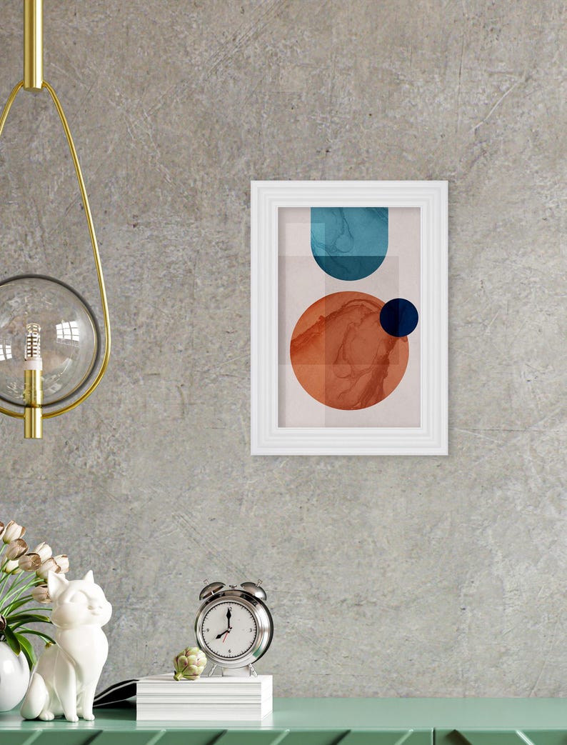 May include: Abstract art print with a white frame. The print features a blue and orange geometric design with a white background.