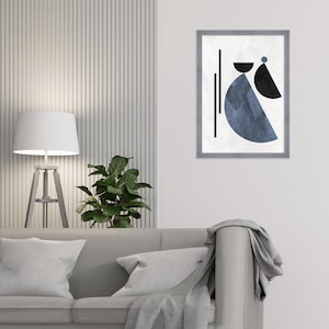 May include: A gray sofa with a throw blanket and two pillows. A white lamp with a white shade is on a wooden stand to the left of the sofa. A green plant is in a pot on the table. A framed print with a blue and black abstract design is on the wall behind the sofa.