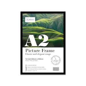 May include: Black picture frame with a white border and the text "A2 Picture Frame Classic and elegant range" and "To hold 420mm x 594mm Photos, Prints, & Posters". The frame is on a white background.