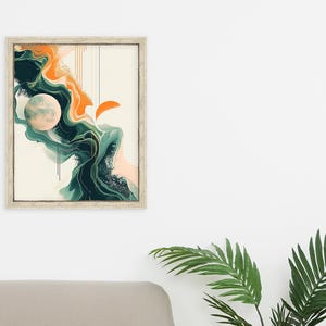 May include: Abstract art print in a white frame with a green, orange, and white color scheme. The print features a large, round, white shape with a textured surface, surrounded by swirling, abstract shapes in shades of green and orange.