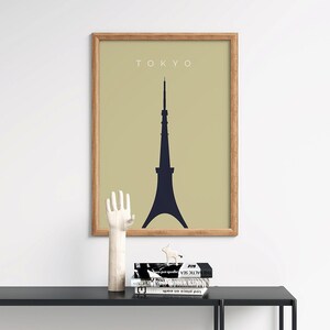 May include: A framed print with a beige background and a black silhouette of the Tokyo Tower. The text "TOKYO" is printed in white at the top of the print.