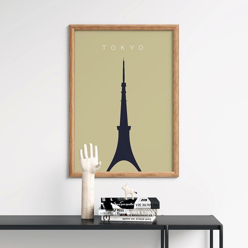 May include: A framed print with a beige background and a black silhouette of the Tokyo Tower. The text "TOKYO" is printed in white at the top of the print.
