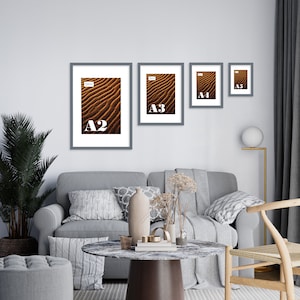 May include: Four gray picture frames with white mats on a white wall. The frames are arranged in a descending size order from left to right. The largest frame is labeled "A2", the next largest is labeled "A3", the next is labeled "A4", and the smallest is labeled "A5".