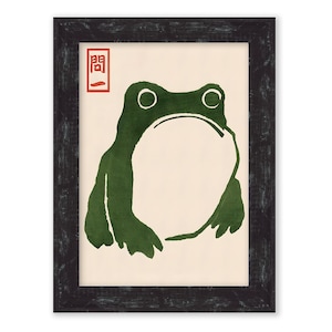 May include: A framed print of a green frog with a white background. The Japanese character "開" is printed in red in the top left corner of the print.
