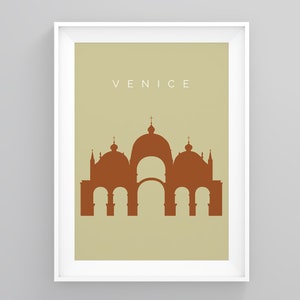May include: A beige poster with a white frame featuring a brown silhouette of a building with multiple domes and arches. The text "VENICE" is printed in white at the top of the poster.
