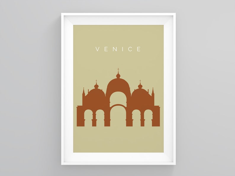 May include: A beige poster with a white frame featuring a brown silhouette of a building with multiple domes and arches. The text "VENICE" is printed in white at the top of the poster.