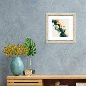 May include: A framed abstract painting with a white background, green and orange swirls, and a white circle in the center.