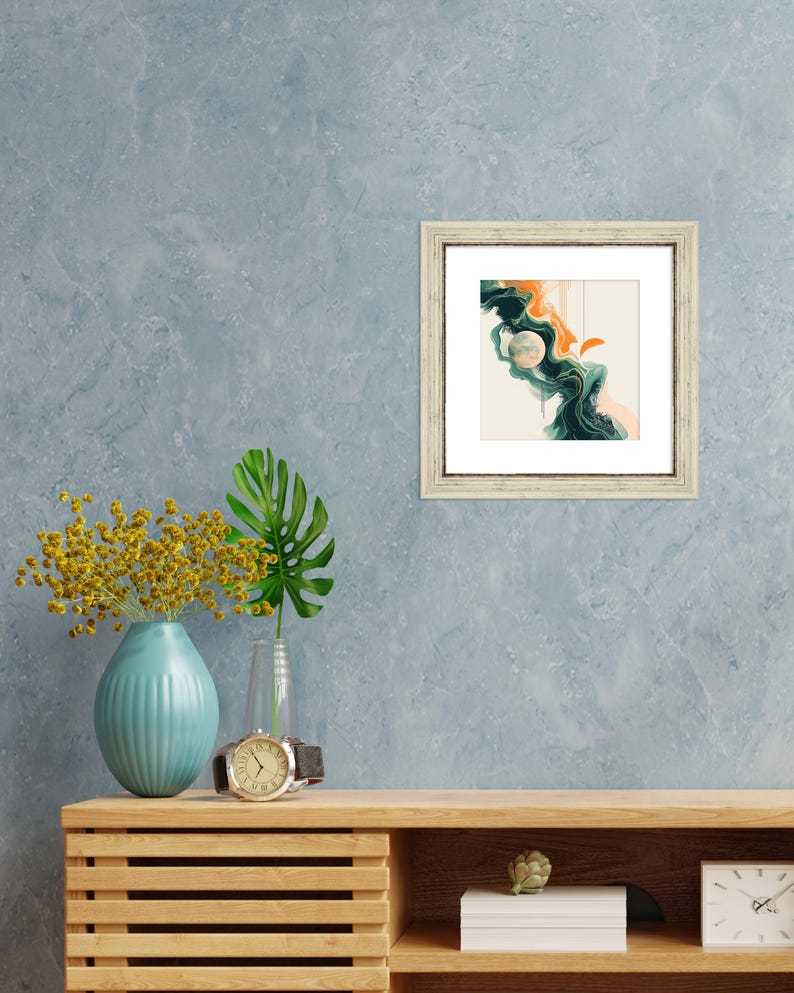 May include: A framed abstract painting with a white background, green and orange swirls, and a white circle in the center.