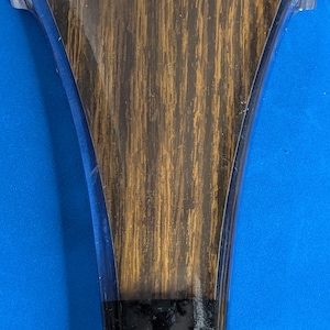 May include: A wooden beer tap handle with a clear plastic top. The top has the word "MICHELOB" printed in white letters with a gold outline.