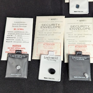 Pode incluir: Quatro envelopes de segurança Lindenwold Fine Jewelers contendo joias. Cada envelope apresenta texto impresso, incluindo 'SECURITY ENVELOPE', 'Lindenwold' e 'Made in the U.S.A.', com pequenas peças de joalharia visíveis em janelas de plástico transparente.