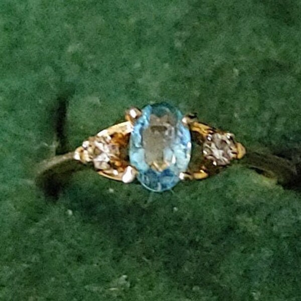 Vintage Fashion Jewelry This is a Oval Blue Topaz Ladies Ring with 2 small round CZ Accents Size 6 It is gold tone and from the 1970's