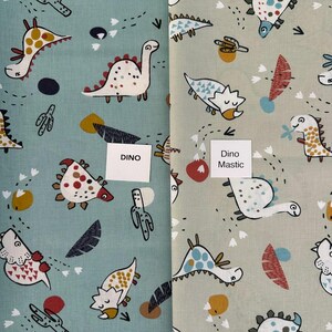 May include: Two fabric swatches with a dinosaur pattern. One is light blue, the other is light green. Both have white dinosaurs with colorful accents, along with other shapes. The light blue swatch has the word "DINO" on a white label.