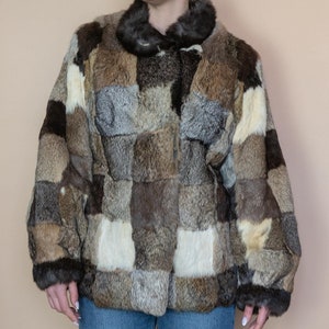 May include: A brown, tan and white patchwork fur jacket with a button fastening.