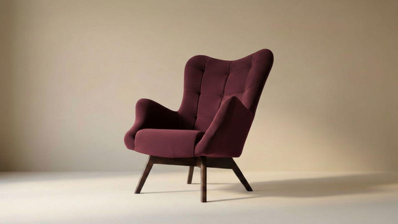 May include: A deep burgundy upholstered armchair featuring a high, tufted backrest with a grid pattern, curved armrests, and a solid dark wood base with four angled legs. The chair has a structured silhouette and a smooth, matte fabric finish.