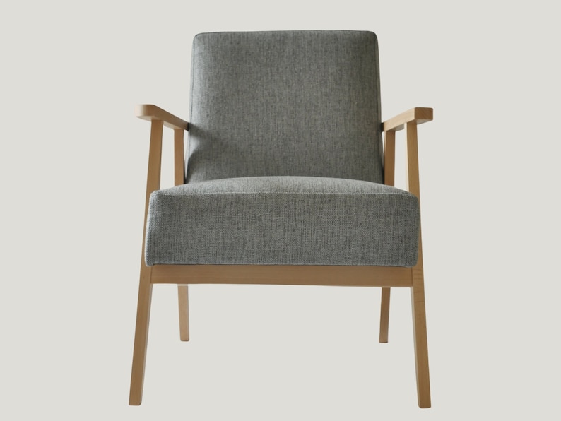 May include: A gray upholstered armchair with wooden legs and arms. The chair has a simple, modern design.