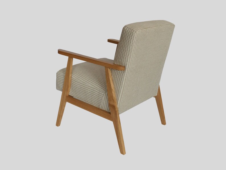 Puede incluir: Un sill&oacute;n beige con tapicer&iacute;a de cuadros y patas y brazos de madera.