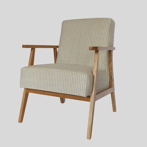 Puede incluir: Un sill&oacute;n de color marr&oacute;n claro con tapicer&iacute;a de tela a cuadros blancos y grises. El sill&oacute;n tiene un marco de madera y cuatro patas.