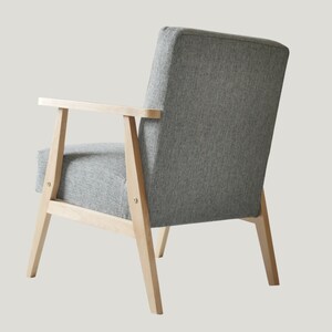 May include: A gray upholstered armchair with wooden legs and arms. The chair has a simple, modern design.
