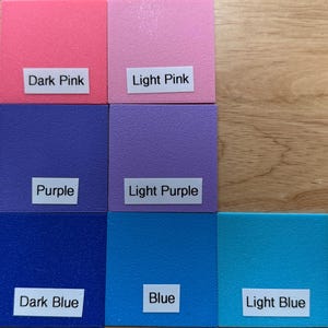 May include: Nine colorful square swatches in shades of pink, purple, and blue. Each swatch has a label with the color name: Dark Pink, Light Pink, Purple, Light Purple, Dark Blue, Blue, and Light Blue.