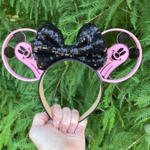 May include: Pink Mickey Mouse ears headband with a black sequined bow. The ears are shaped like ghosts with Mickey Mouse faces.