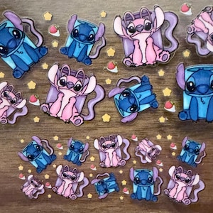 May include: A collection of colorful stickers featuring the characters Stitch and Angel from the animated movie Lilo & Stitch. The stickers are in various poses and surrounded by star and strawberry-shaped accents.