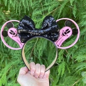 May include: Pink Mickey Mouse ears with a black sequin bow and a ghost design on each ear.