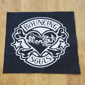 May include: Black and white embroidered patch with the words "BOUNCING SOULS" and a broken heart with a lightning bolt inside.