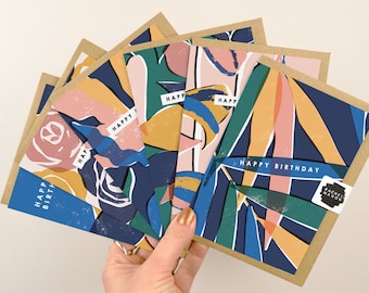 May include: A set of five colorful birthday cards with abstract floral designs in shades of blue, green, yellow, pink, and orange. The cards have the text "Happy Birthday" printed on them.