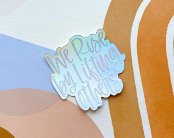 We Rise By Lifting Others | Holographic Vinyl Die Cut Sticker | Accessory | Decorate | Rainbow | Laptop Sticker | Water Bottle Sticker