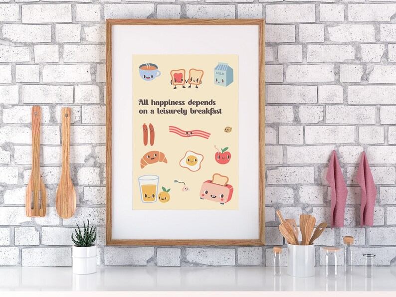 May include: A framed print with a yellow background and illustrations of breakfast foods with faces. The text reads "All happiness depends on a leisurely breakfast."