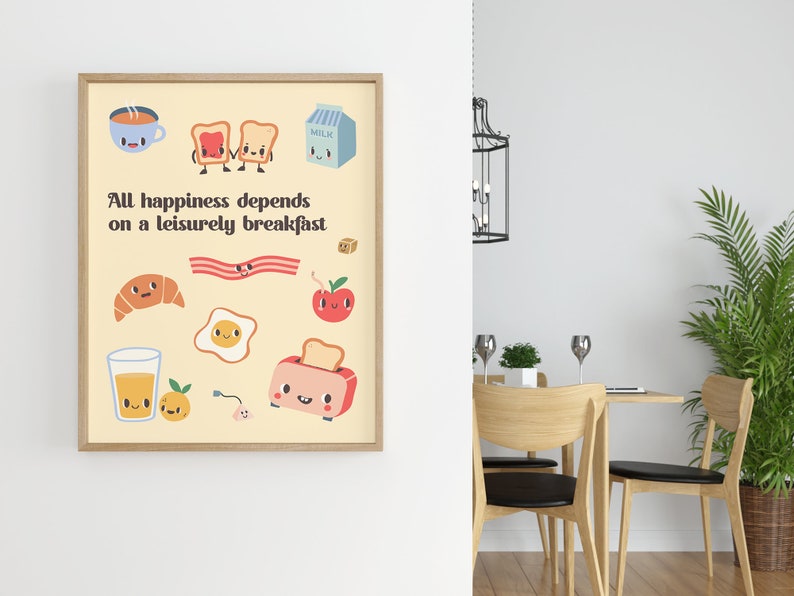 May include: A framed print with a yellow background and the text "All happiness depends on a leisurely breakfast."  The print features cartoon illustrations of breakfast foods, including a cup of coffee, toast, bacon, an egg, a croissant, an apple, a glass of orange juice, and a toaster.