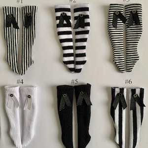 May include: Six pairs of black and white striped knee-high socks with black bows. The socks are numbered 1 through 6.
