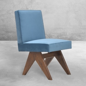 May include: A blue velvet chair with a wooden frame and four legs. The chair has a simple, modern design.