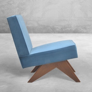 May include: A blue upholstered chair with a wooden frame and a unique angled base.