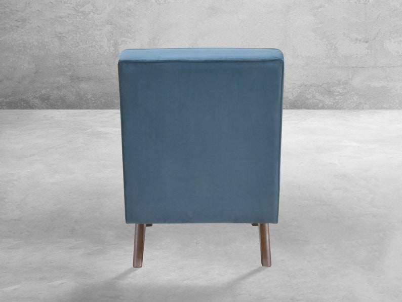 May include: A blue velvet armchair with wooden legs. The chair is shown from the back.
