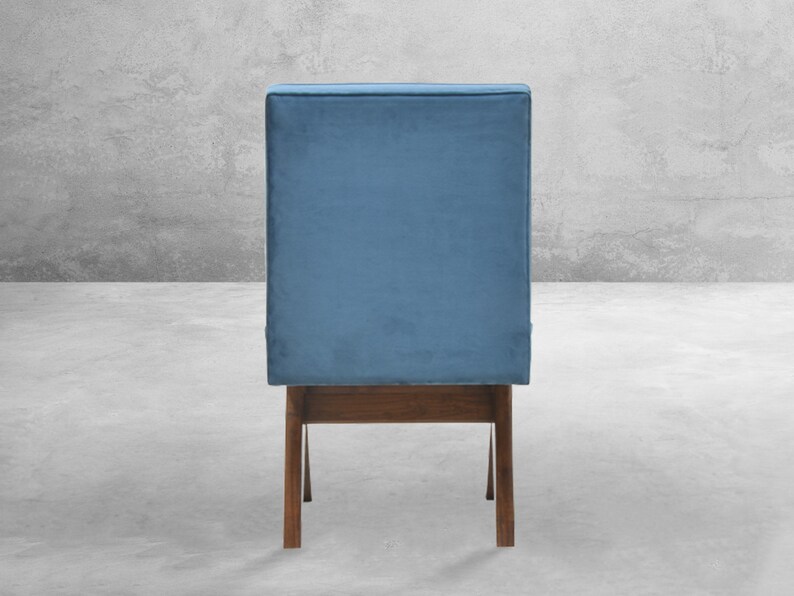 May include: A blue velvet chair with a wooden frame. The chair has a simple design with a rectangular seat and back.