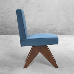 May include: A blue upholstered chair with a wooden base. The chair has a simple, modern design with a triangular base.