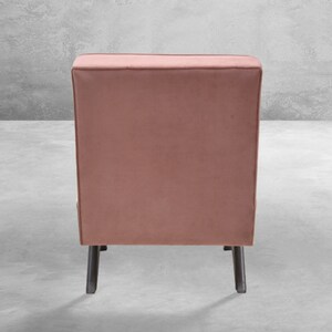 May include: A dusty rose velvet armchair with black legs. The chair is shown from the back.