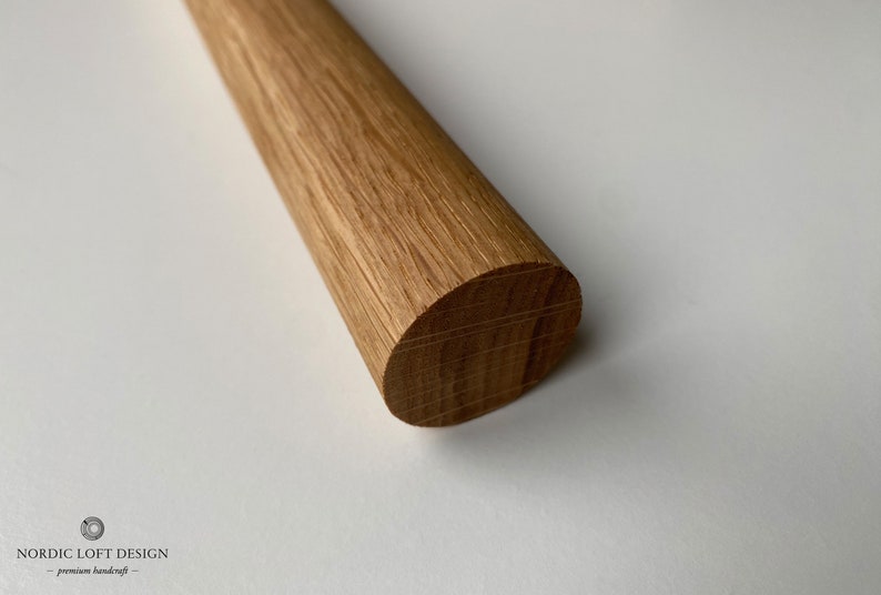 Puede incluir: Primer plano de una varilla de madera redonda con un acabado liso de color marr&oacute;n claro. La veta de la madera es visible y el extremo de la varilla est&aacute; ligeramente redondeado.