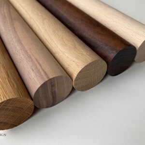 Puede incluir: Cinco clavijas de madera de diferentes tipos de madera, incluyendo roble, nogal y arce. Las clavijas est&aacute;n dispuestas en una fila de izquierda a derecha, con la clavija de roble a la izquierda y la clavija de arce a la derecha.