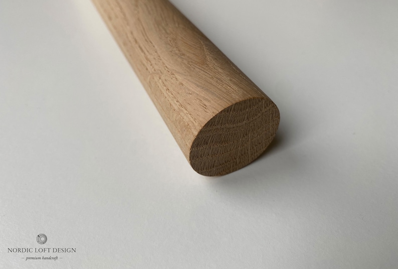 Puede incluir: Primer plano de una varilla de madera redonda. La madera tiene un color marr&oacute;n claro natural y un acabado liso y pulido.