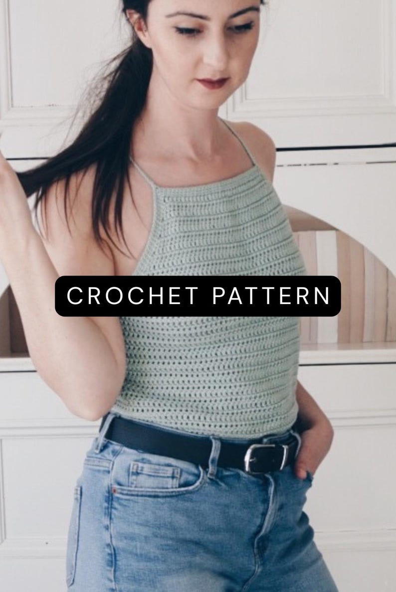 K&ouml;nnte beinhalten: Ein helles, salbeigr&uuml;nes H&auml;kel-Neckholder-Top mit quadratischem Ausschnitt und d&uuml;nnen Tr&auml;gern, das den Text CROCHET PATTERN in einem schwarzen rechteckigen Feld zeigt. Das Kleidungsst&uuml;ck wird mit einer blauen Jeans und einem schwarzen Lederg&uuml;rtel kombiniert.