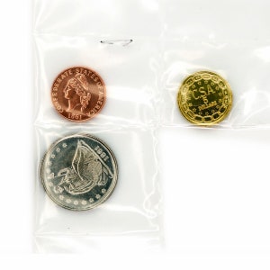 Puede incluir: Tres monedas doradas en fundas de plástico. Las monedas son una moneda de color cobre con el texto "CONFEDERATE STATES OF AMERICA 1861", una moneda plateada con el texto "1861" y una moneda dorada con el texto "CSA 5 DOLLARS".
