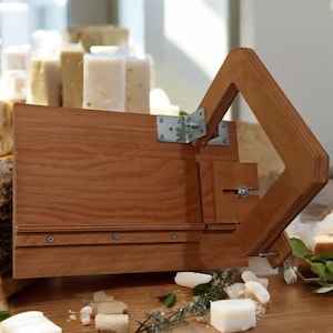 Pu&ograve; includere: Un tagliapanni per sapone in legno con una maniglia a cerniera e una staffa in metallo. Il tagliapanni &egrave; realizzato in legno marrone chiaro e ha una superficie liscia. La maniglia &egrave; realizzata in legno marrone scuro e ha una superficie ruvida. Il tagliapanni &egrave; progettato per tagliare le barre di sapone in pezzi pi&ugrave; piccoli.