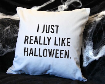 May include: A light blue cushion with the text "I just really like Halloween." printed in black.