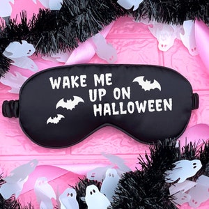 May include: Black sleep mask with the text "Wake Me Up On Halloween" and a white bat design.