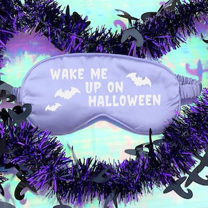 May include: Purple sleep mask with the text "Wake me up on Halloween" and bat silhouettes.
