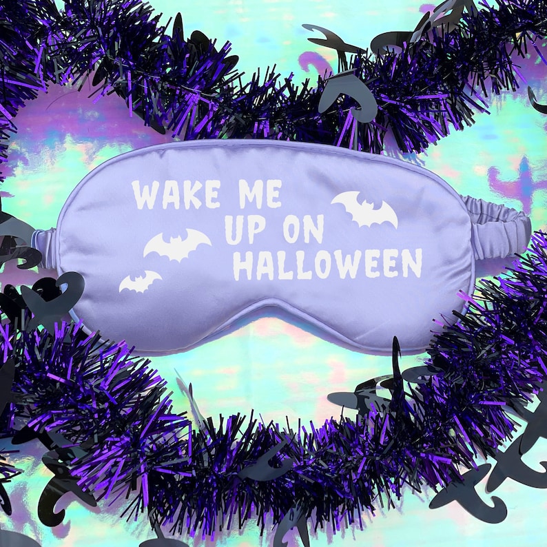 May include: Purple sleep mask with the text "Wake me up on Halloween" and bat silhouettes.