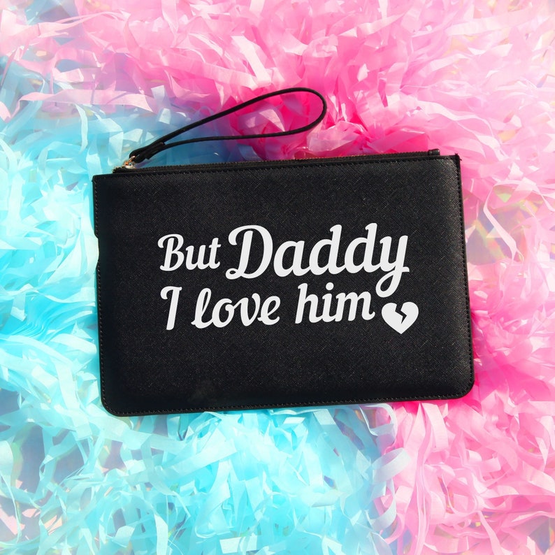 May include: Black clutch bag with a white inscription that reads "But Daddy I love him" with a broken heart symbol.
